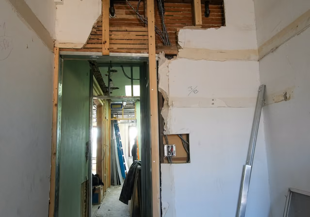 Interior demolition showing exposed studs and removed drywall